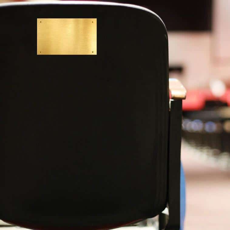 Image of an auditorium chair with a blank plaque on the back