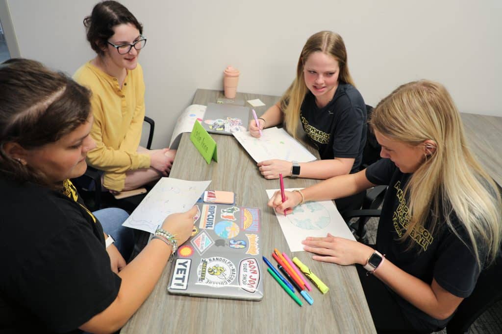 A group of education students work on lesson plans together while sitting at a table