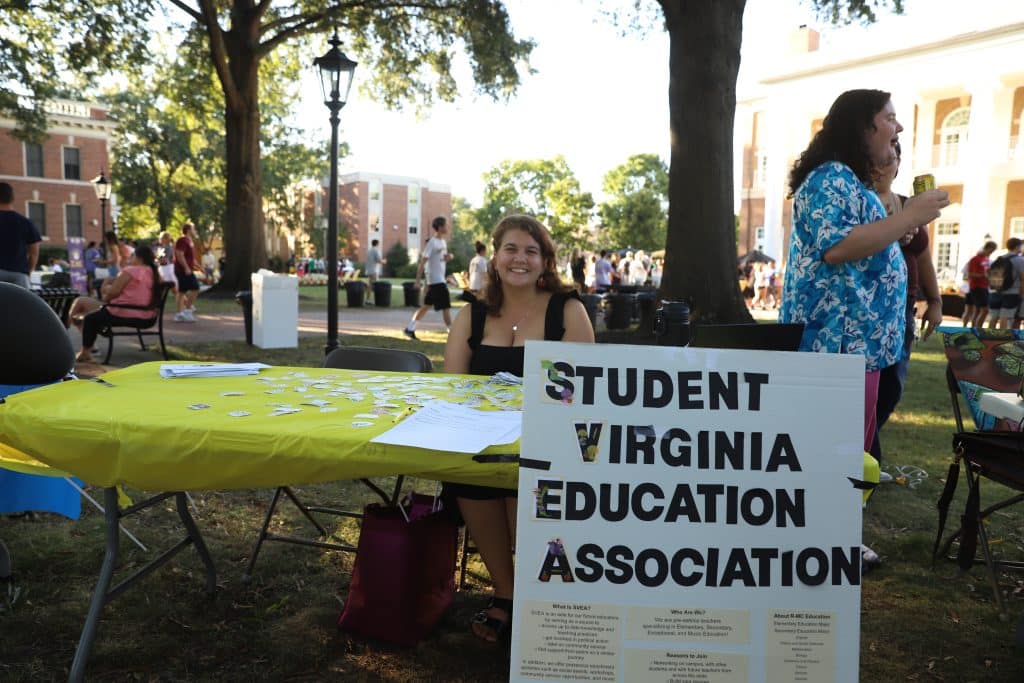 An education student sits at recruitment table for the Student Virginia Education Association