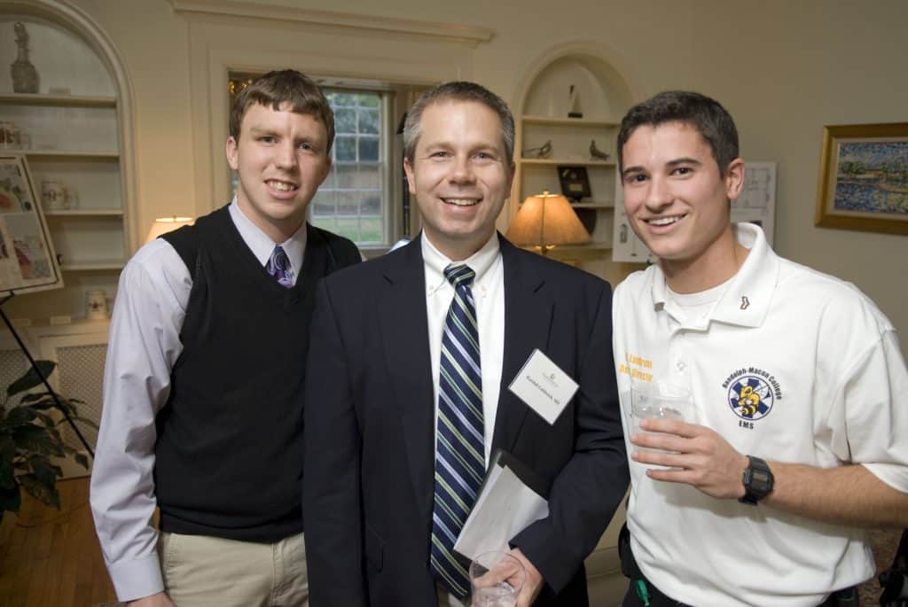 2 students with a doctor alum at a networking event