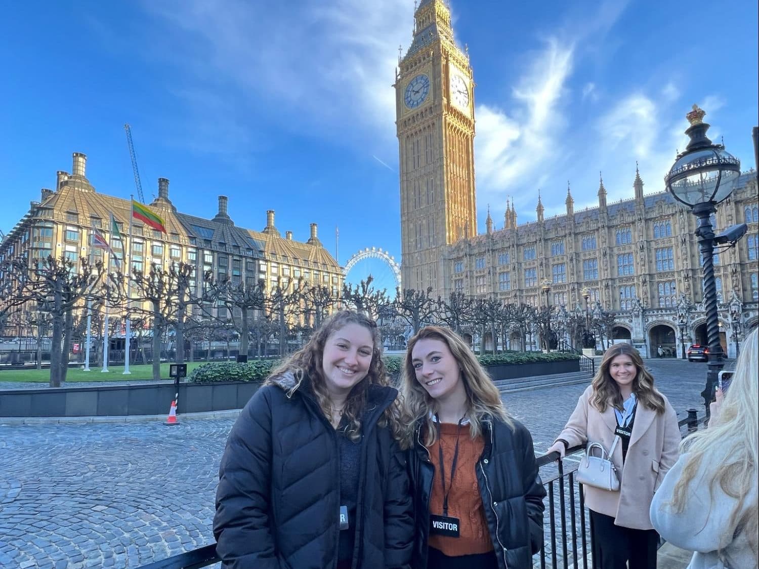 Two students in front of Big Ben and the London Eye in London, England.