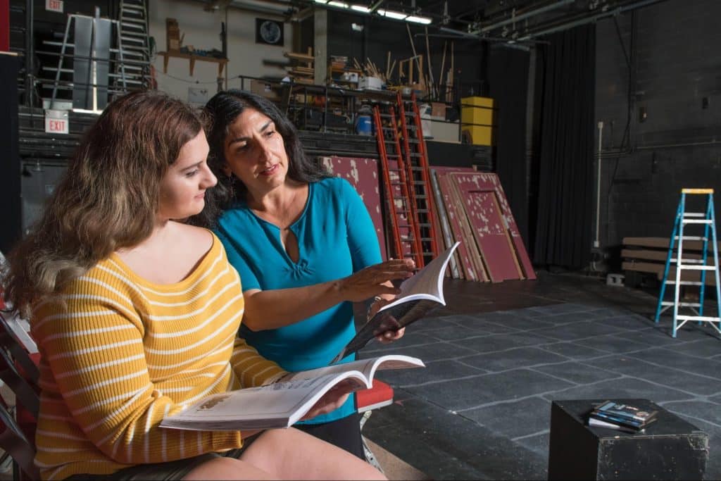 Student and faculty member looking at a script together