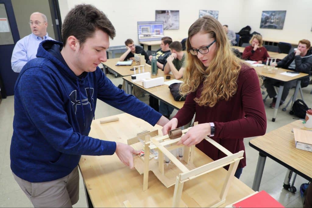 Two engineering students working on project in class
