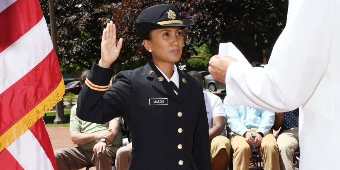 ROTC student stands with hand raised while taking an oath