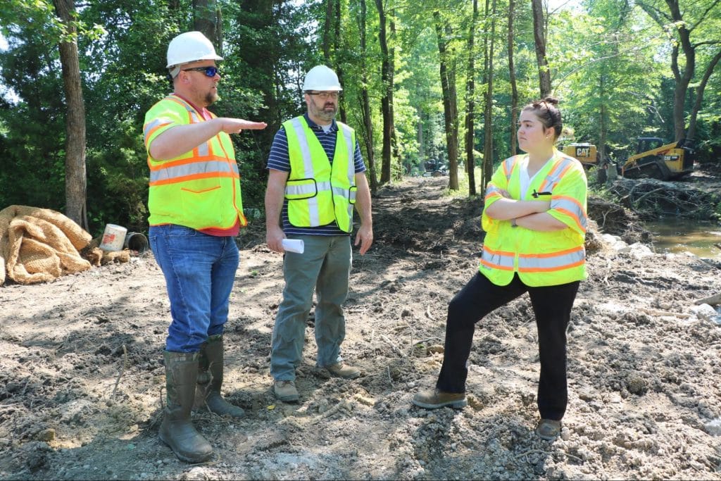 Environmental studies student talking with officials at research site