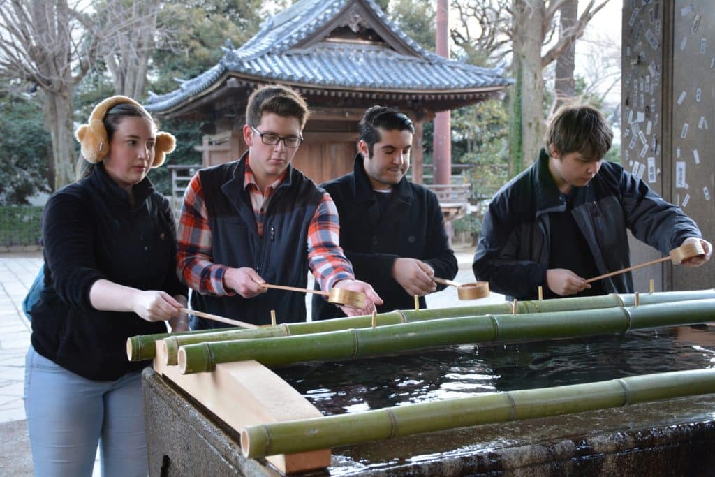 RMC music students washing their hands after touring a Japanese Buddhist temple