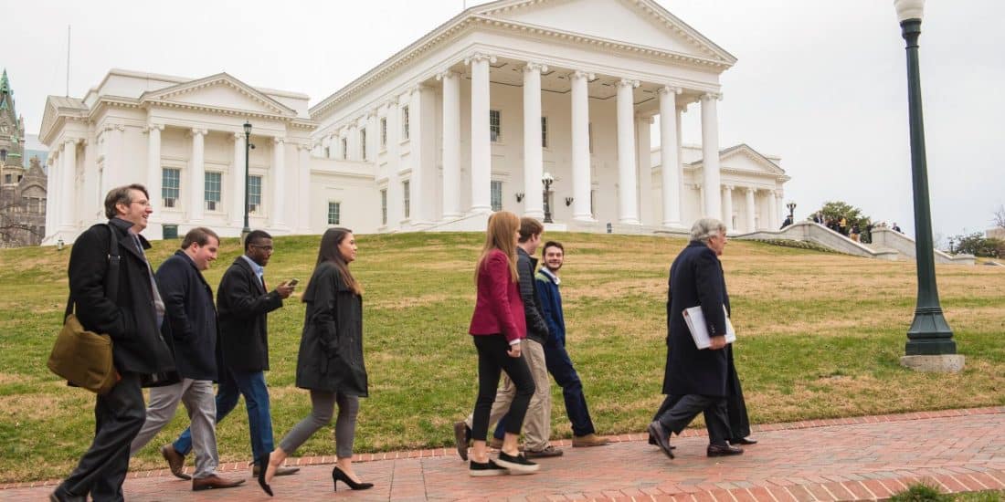 Students walking with the Virginia state capitol in the background