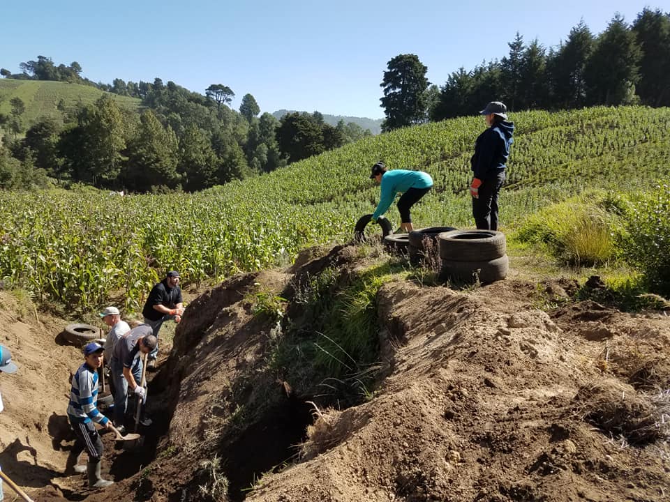 Engineering physics students on-site in Guatemala digging in a dirt hill