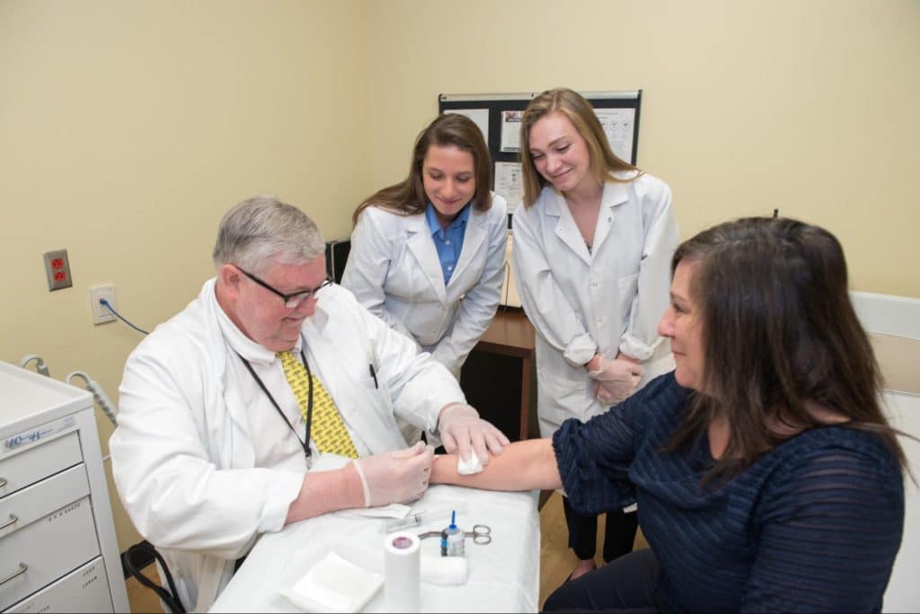 Pre-med students observe a medical procedure