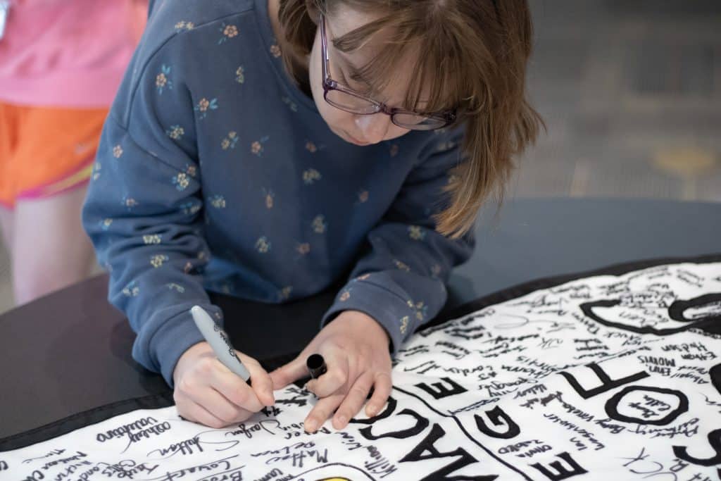 student signing a banner