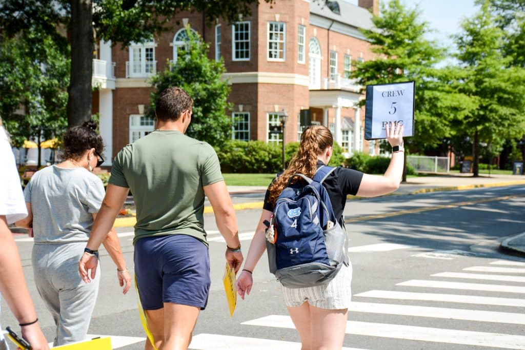 A group of people transitioning to college crossing a street.