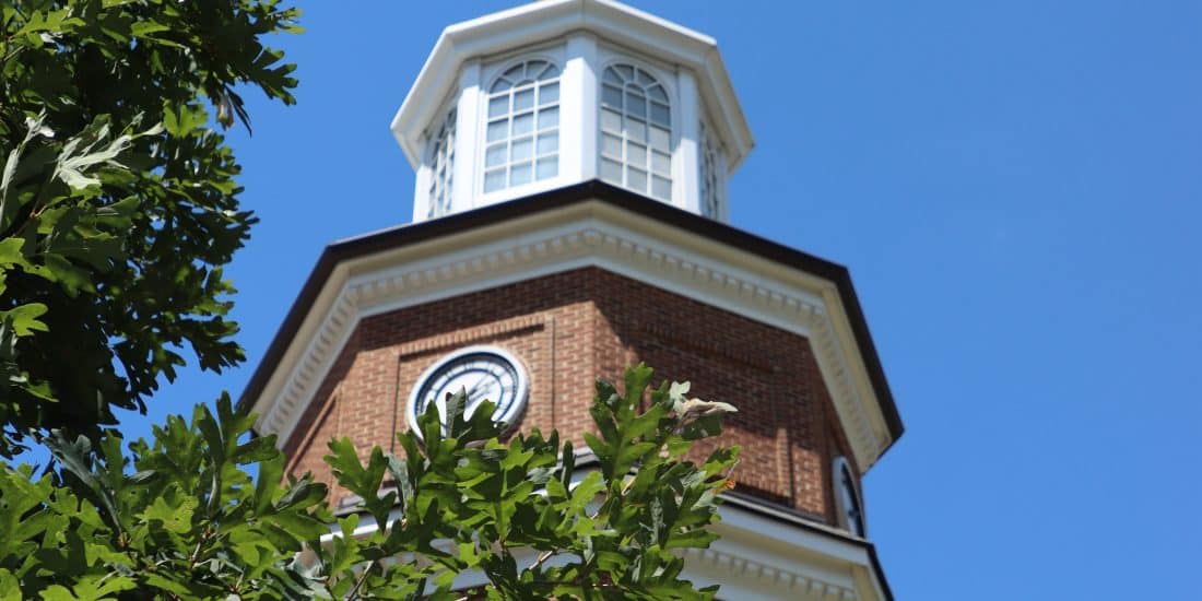 A clock tower located in a brick building, specifically for admitted students.