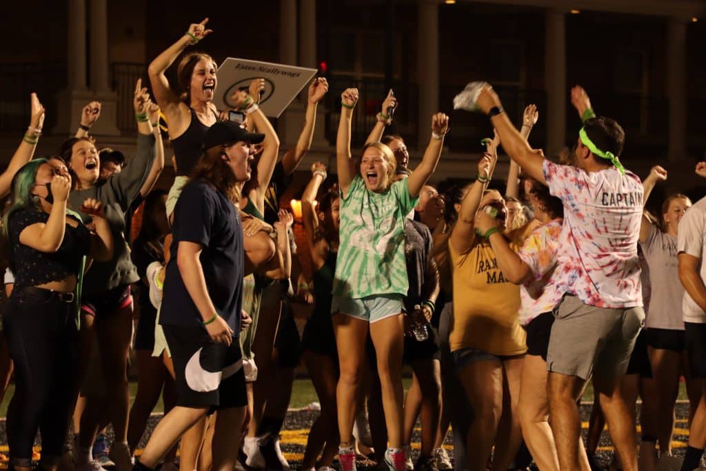 A group of college students cheering on a football field.