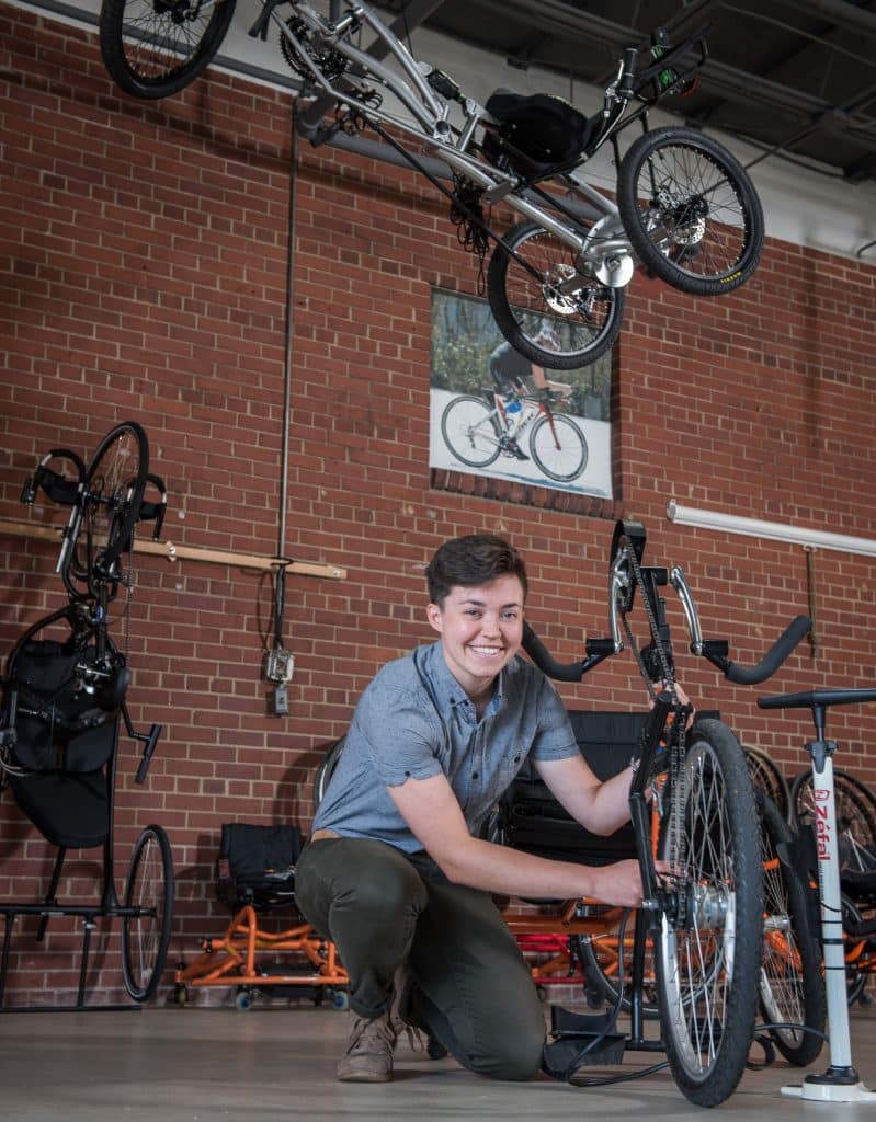 A man completing internships while kneeling down with a bike.