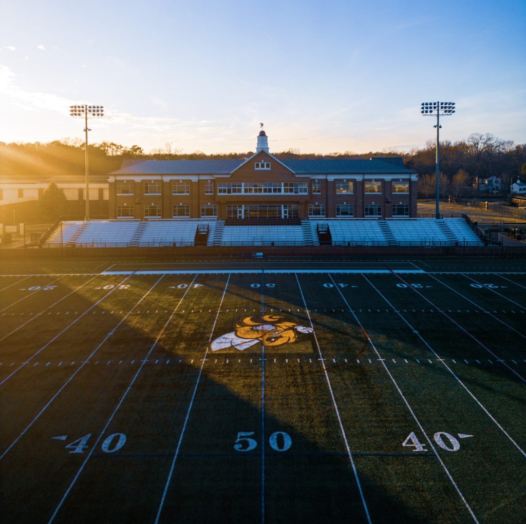 An aerial view of Duke Hall and Day Field at sunset.