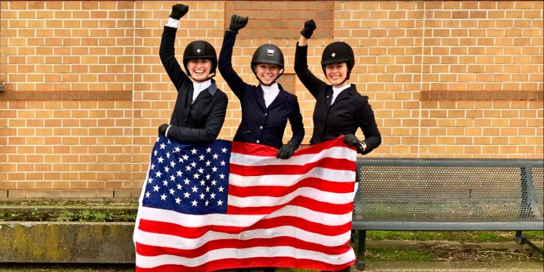 Three equestrians holding an american flag.