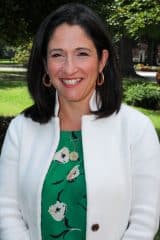 Beth Campbell, a smiling woman in a white jacket and green top.