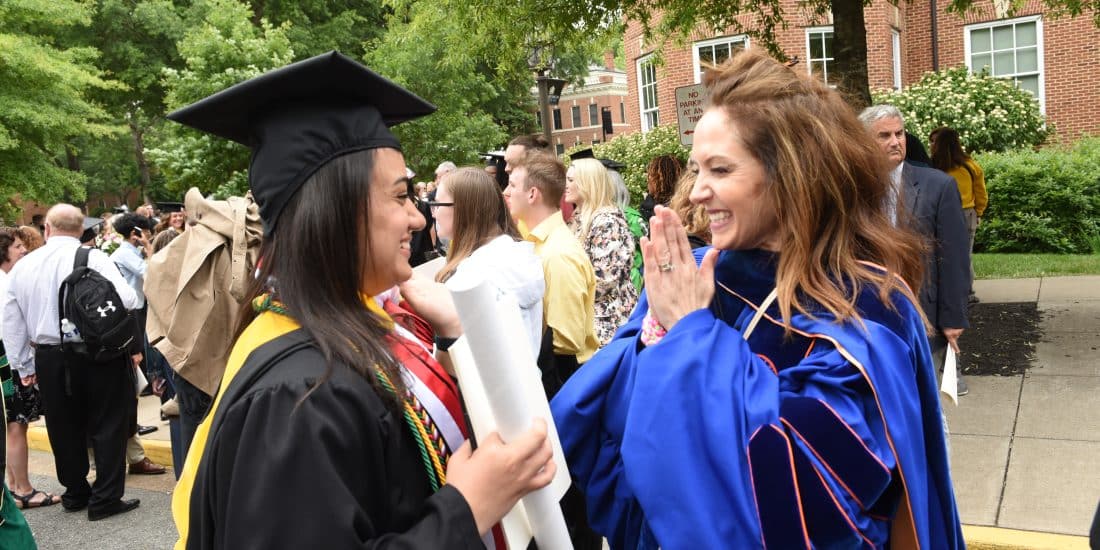 Student and professor celebrating graduation