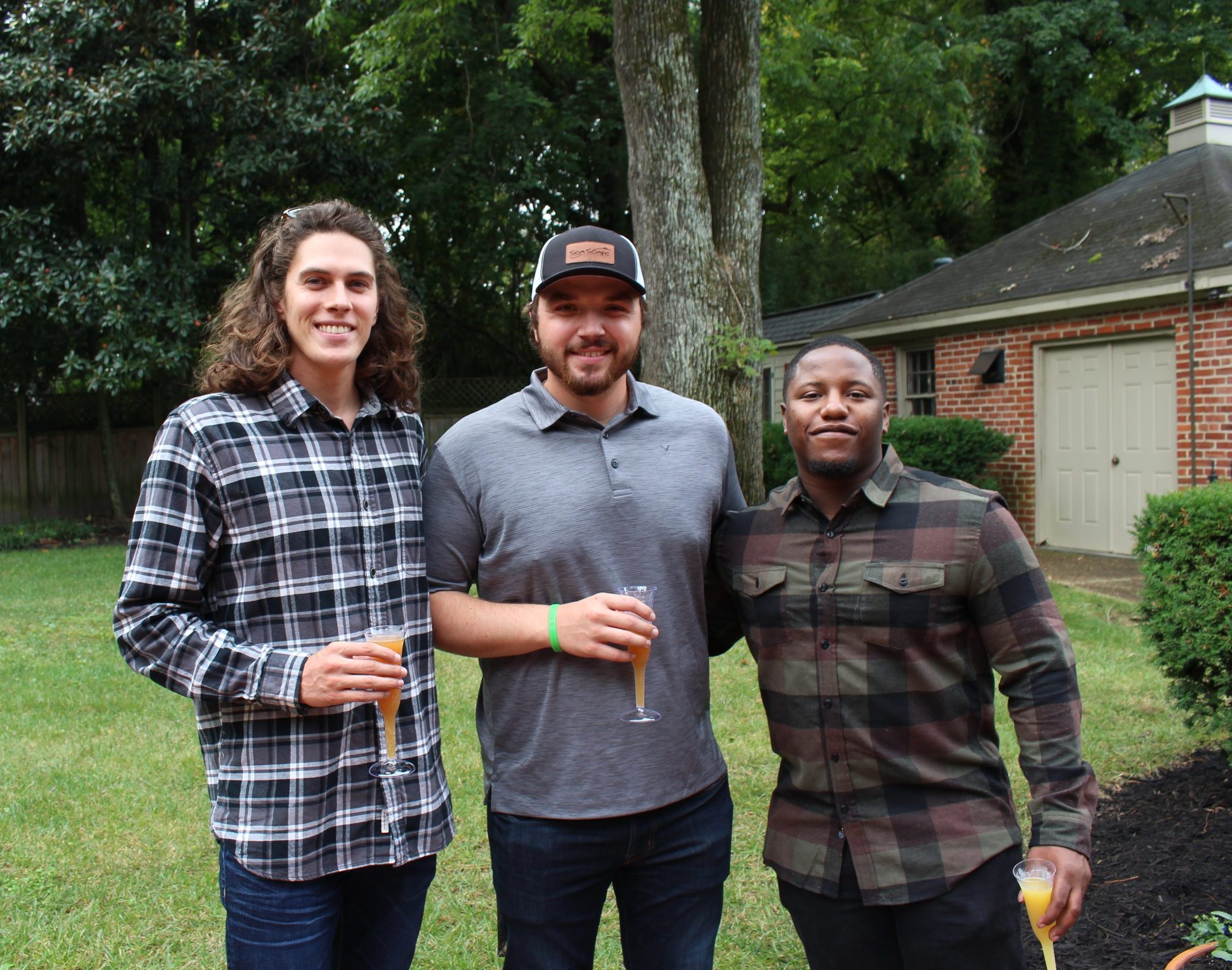 Three men posing for a picture during the event "Macon Mimosas"